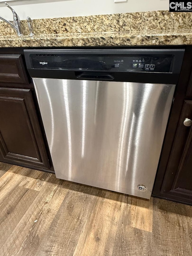 details with light wood-style floors, light stone countertops, stainless steel dishwasher, and dark brown cabinets