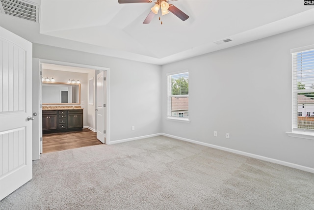 unfurnished bedroom featuring vaulted ceiling, baseboards, visible vents, and carpet floors