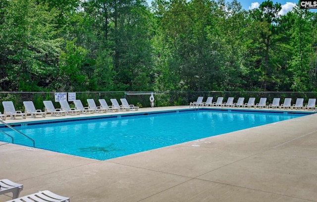 pool with a patio and fence