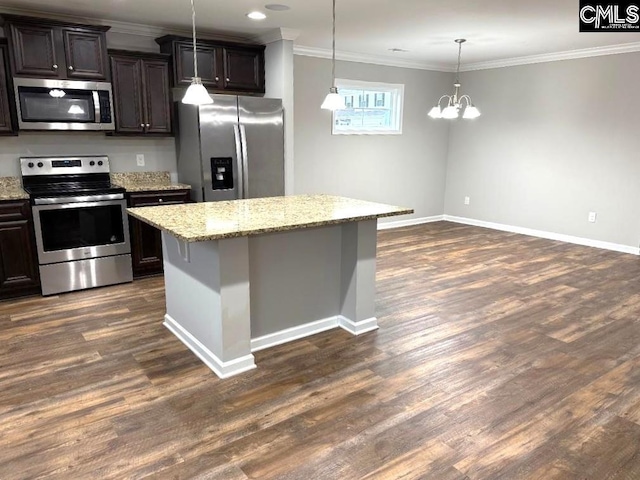 kitchen with a center island, light stone countertops, dark wood finished floors, ornamental molding, and stainless steel appliances