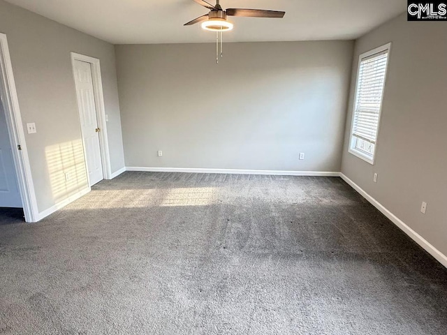 carpeted spare room featuring baseboards and ceiling fan