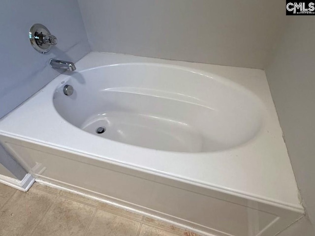 bathroom featuring tile patterned flooring and a tub to relax in