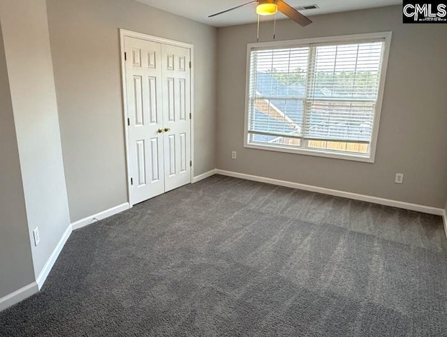 unfurnished bedroom with a ceiling fan, visible vents, baseboards, a closet, and dark carpet