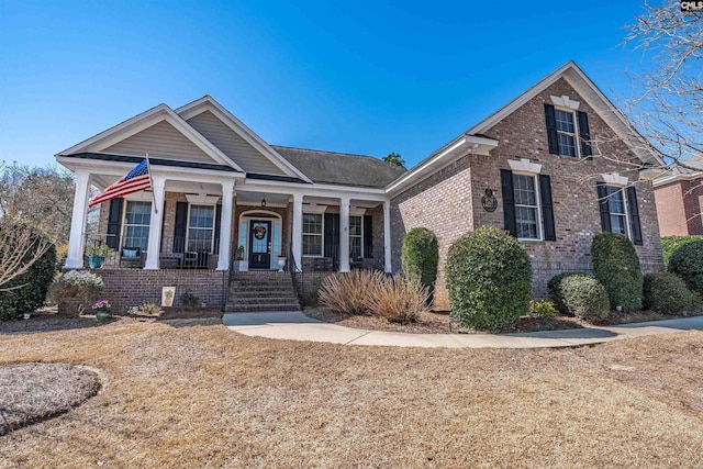 view of front of property featuring brick siding and covered porch