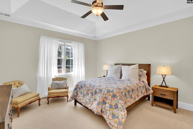 carpeted bedroom with visible vents, ornamental molding, a ceiling fan, a tray ceiling, and baseboards