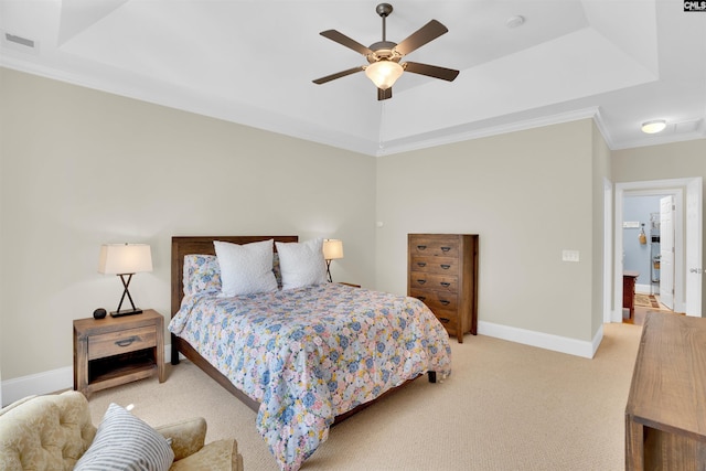 bedroom with visible vents, baseboards, a tray ceiling, ornamental molding, and light colored carpet