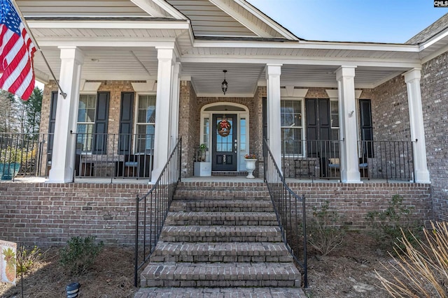 property entrance with brick siding and a porch