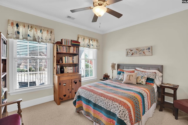 carpeted bedroom with a ceiling fan, crown molding, baseboards, and visible vents