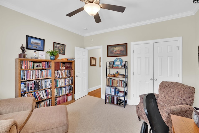 living area with baseboards, carpet, a ceiling fan, and crown molding