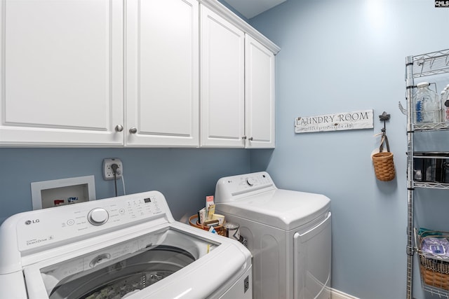 clothes washing area featuring cabinet space and washer and dryer