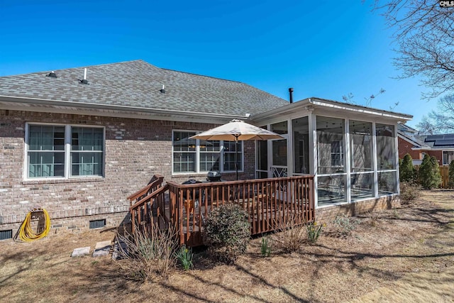 rear view of house featuring brick siding, crawl space, roof with shingles, and a sunroom