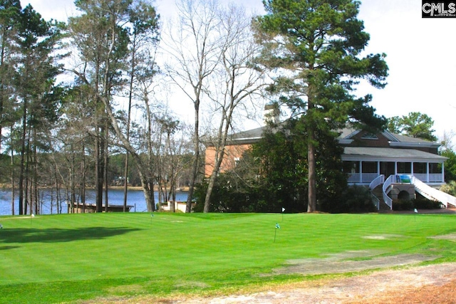 view of home's community with stairway, a water view, and a lawn