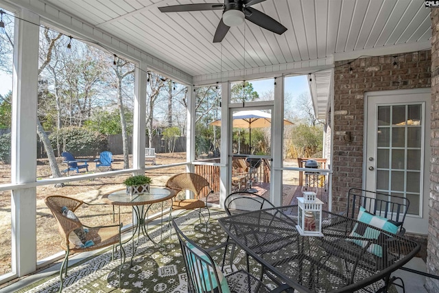 sunroom featuring ceiling fan and wooden ceiling