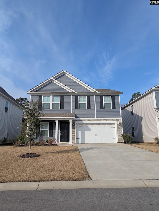 view of front of house featuring a garage, stone siding, and driveway