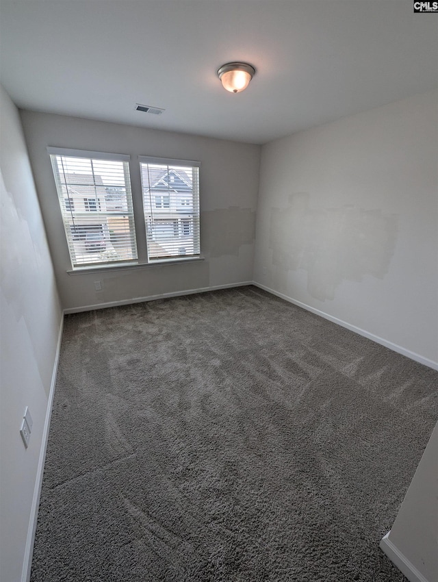 empty room featuring visible vents, baseboards, and carpet floors