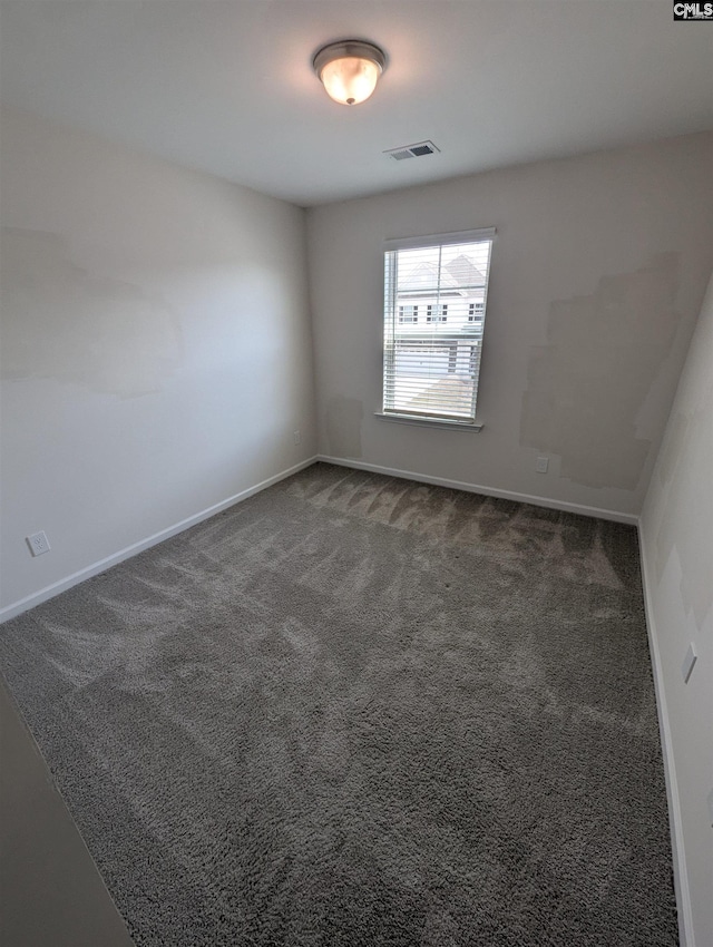 carpeted spare room featuring visible vents and baseboards