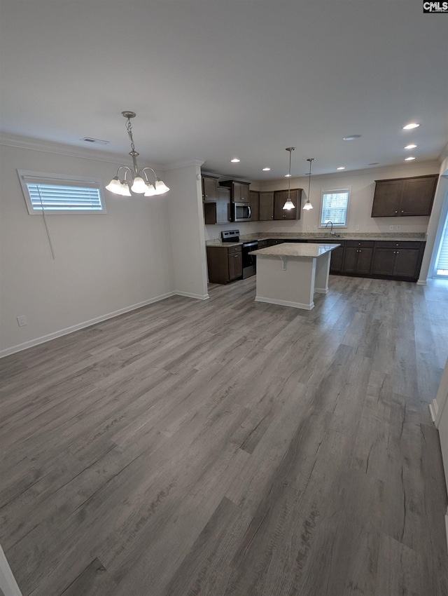 kitchen with dark brown cabinets, light wood-style floors, open floor plan, and stainless steel appliances