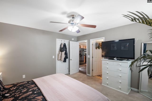 bedroom featuring light carpet, black fridge with ice dispenser, and a ceiling fan