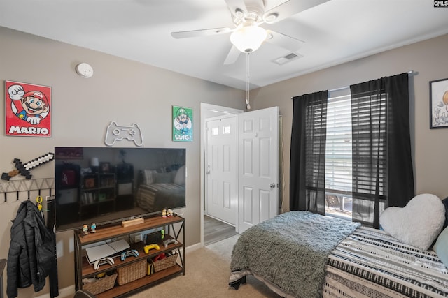 carpeted bedroom with visible vents, baseboards, and ceiling fan