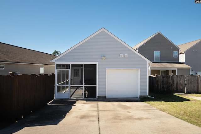 rear view of property with a lawn, fence, and a sunroom