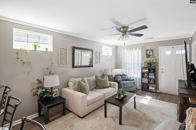 living room with visible vents, a healthy amount of sunlight, wood finished floors, and a ceiling fan