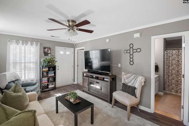 living room with baseboards, wood finished floors, ceiling fan, and crown molding