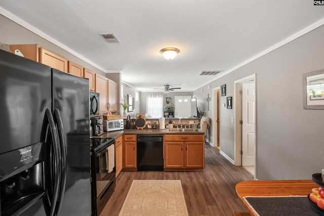 kitchen featuring dark countertops, visible vents, a peninsula, and black appliances