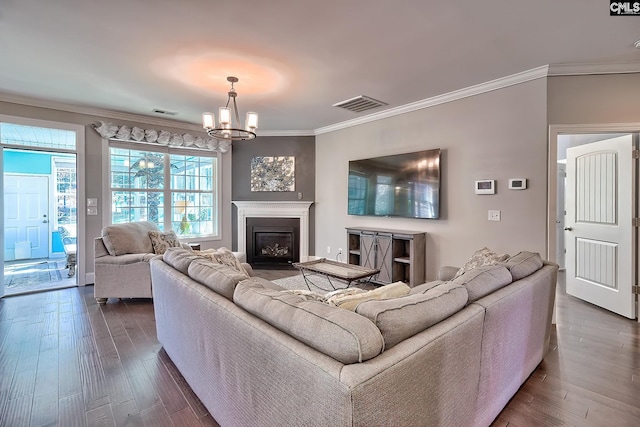 living room featuring a notable chandelier, visible vents, crown molding, and dark wood-style flooring