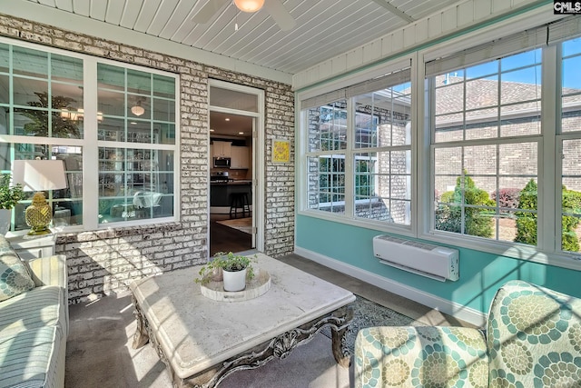 sunroom / solarium featuring a wall unit AC and a ceiling fan