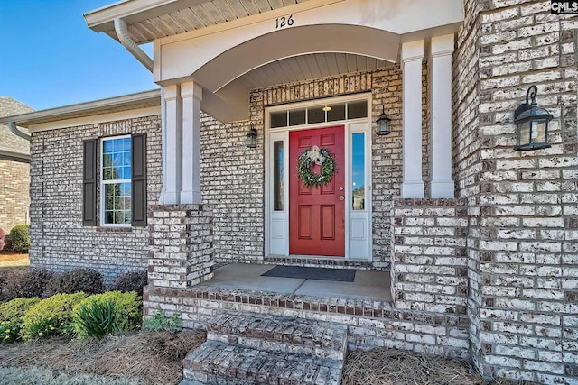 doorway to property with brick siding