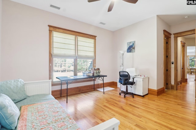 office with visible vents, baseboards, light wood-type flooring, and a ceiling fan