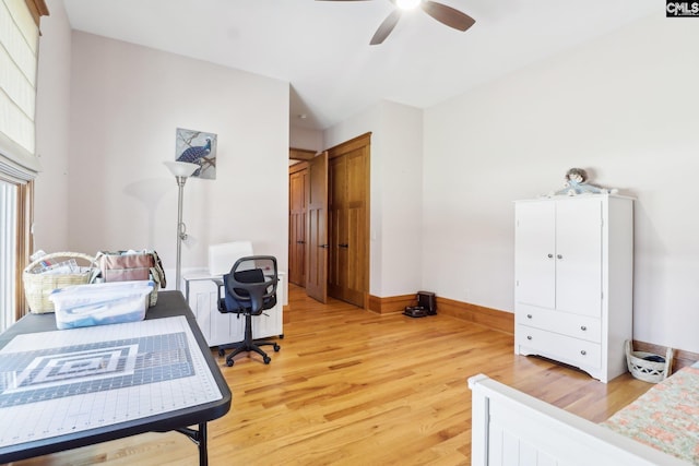 office area featuring light wood-type flooring, baseboards, radiator, and a ceiling fan