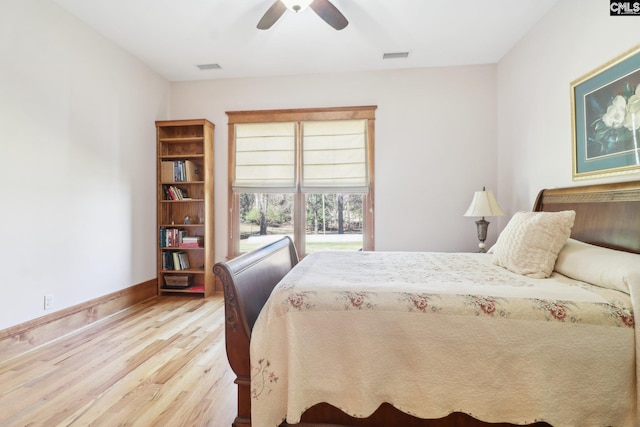 bedroom featuring ceiling fan, wood finished floors, visible vents, and baseboards