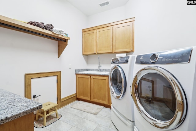 laundry room with visible vents, light tile patterned flooring, cabinet space, separate washer and dryer, and a sink