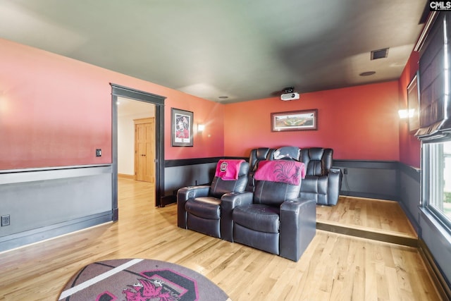 cinema room with wood finished floors and visible vents