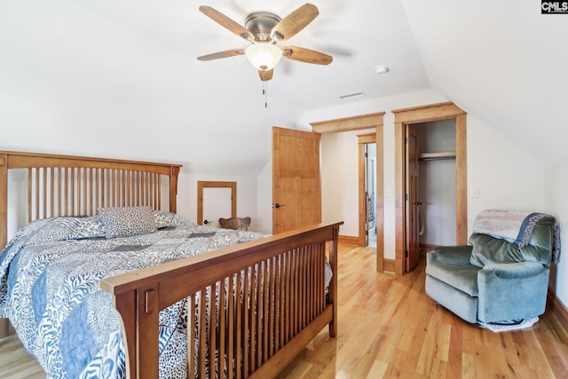 bedroom with visible vents, ceiling fan, lofted ceiling, light wood-style flooring, and a closet