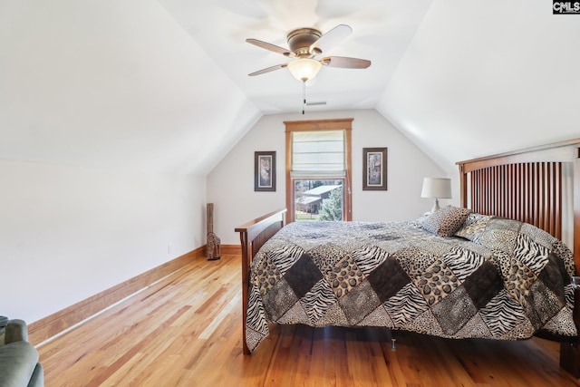 bedroom featuring visible vents, baseboards, ceiling fan, vaulted ceiling, and wood finished floors