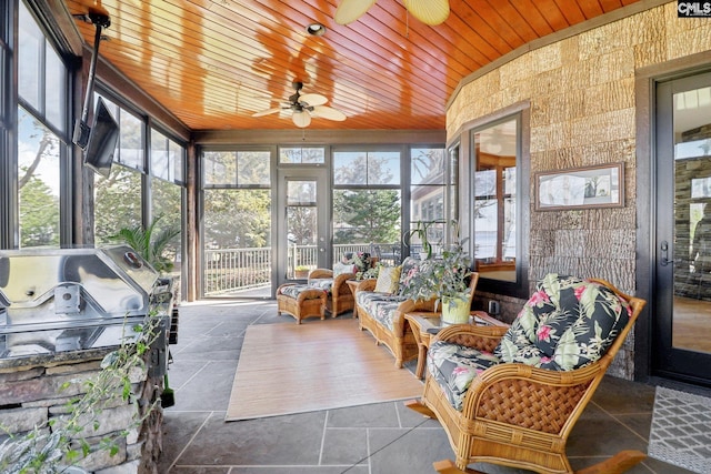 sunroom with wood ceiling and ceiling fan