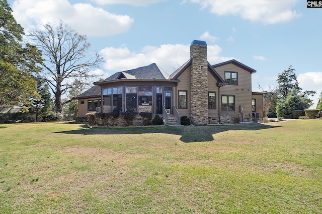 back of property featuring a lawn, a chimney, and a sunroom