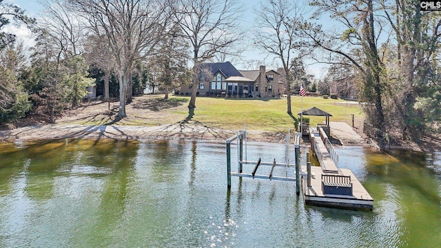 view of dock with a yard and a water view