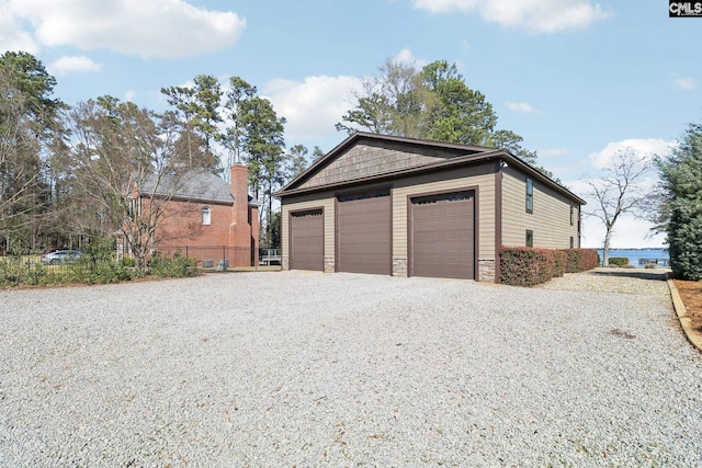 garage featuring driveway and fence