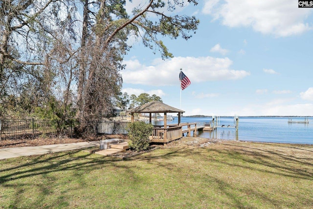 view of dock featuring a gazebo, fence, a yard, and a water view