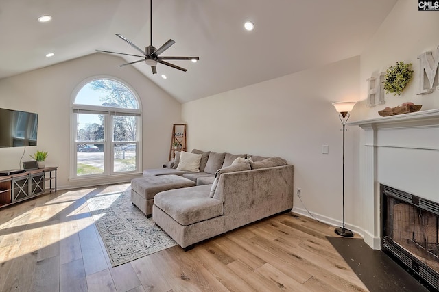 living room with light wood finished floors, ceiling fan, lofted ceiling, recessed lighting, and a fireplace