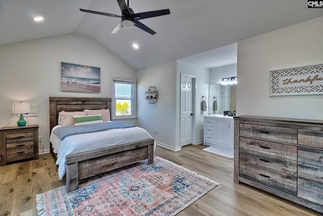 bedroom featuring connected bathroom, baseboards, light wood-type flooring, and lofted ceiling