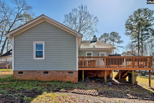 rear view of property with crawl space, a deck, and stairs