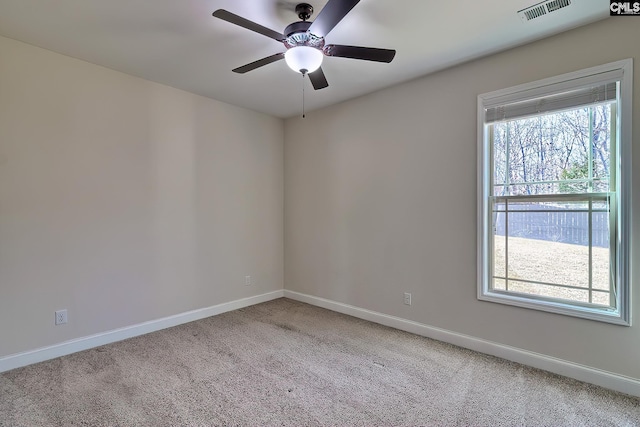 carpeted spare room featuring visible vents, ceiling fan, and baseboards