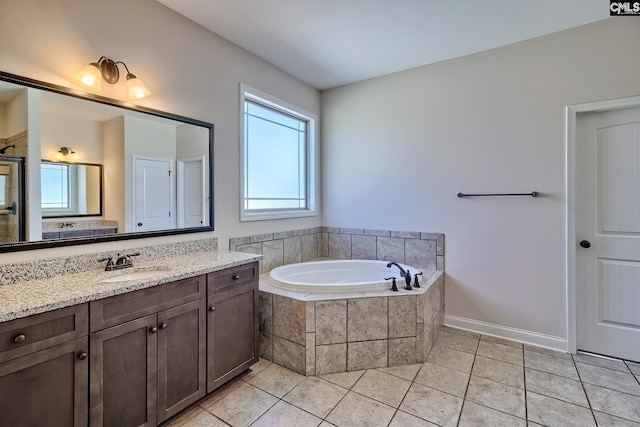 bathroom featuring tile patterned flooring, a bath, and vanity