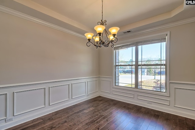 spare room with dark wood-style floors, visible vents, an inviting chandelier, a tray ceiling, and crown molding