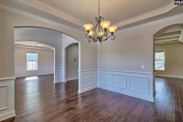 empty room with arched walkways, a notable chandelier, a healthy amount of sunlight, and dark wood-style flooring