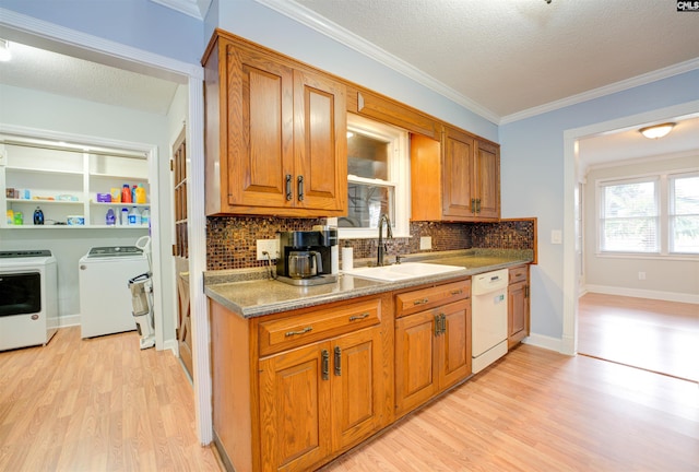 kitchen featuring independent washer and dryer, light wood-style floors, dishwasher, and brown cabinetry